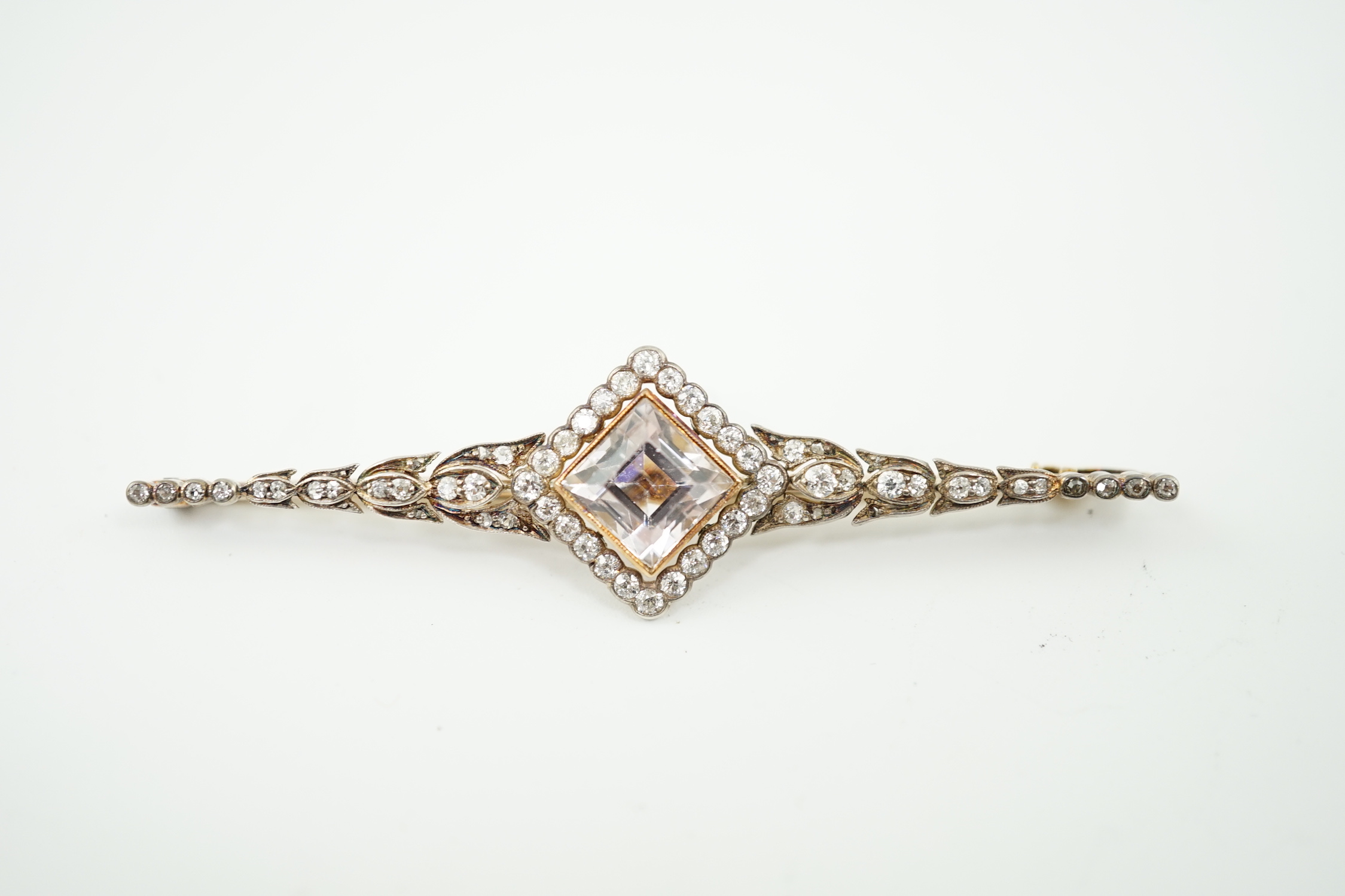 An early to mid 20th century gold and silver, pale pink topaz and millegrain set diamond cluster bar brooch